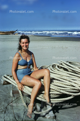 Woman sitting on a Coil of Rope, Beach