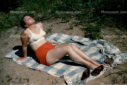 Woman in a bra sunning herself, 1950s