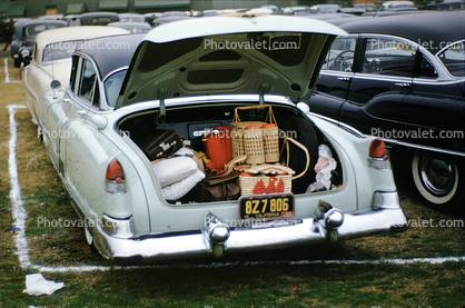Cadillac, trunk filled with picnic baskets, open trunk, bumper, 1955, 1950s