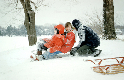 Children on a sled, girl, boy, dad, 1970s