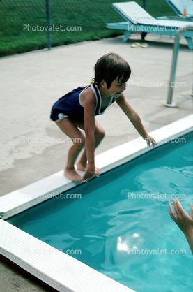 little girl jumping into a swimming pool