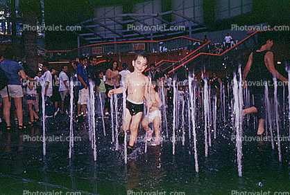 Boy Running Through Water Fountain