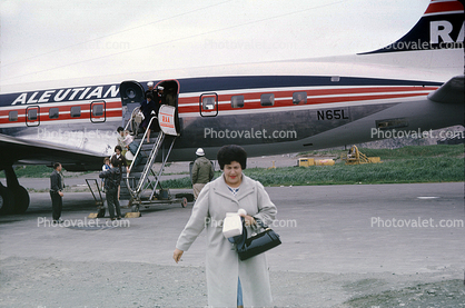 N65L, Reeve Aleutian Airways, Douglas DC-6B, Passenger, Woman, Purse, Coat, Alaska, 1950s