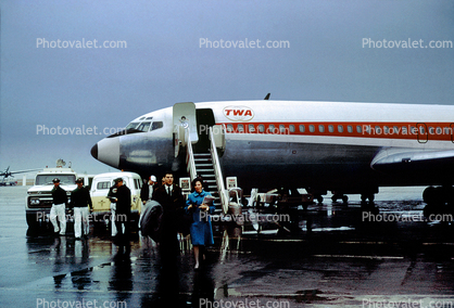 Trans World Airlines TWA, Boeing 707, stairs, rain, disembarking passengers, 1960s