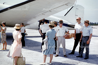 Passengers getting ready to board, men, women, hats, dresses, wind, windy, 1950s