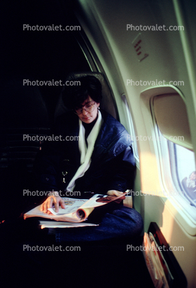 Woman sitting, reading a magazine, window, seat