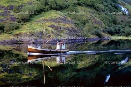 Small fishing trawler on a calm reflective Fjord