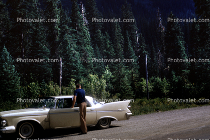 1958 Plymouth Fury, fins, four-door sedan, dirt highway, trees, forest, August 1962, 1960s