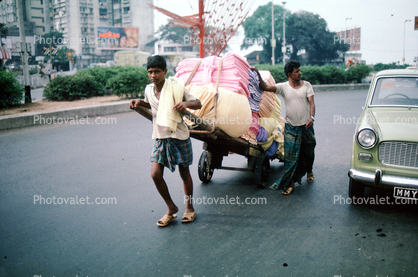 Men, Pulling a laundry Cart, pushing, on the Streets of Mumbai