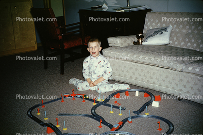 Boy and his toy railroad set, tracks, Pajamas, sofa, 1960s