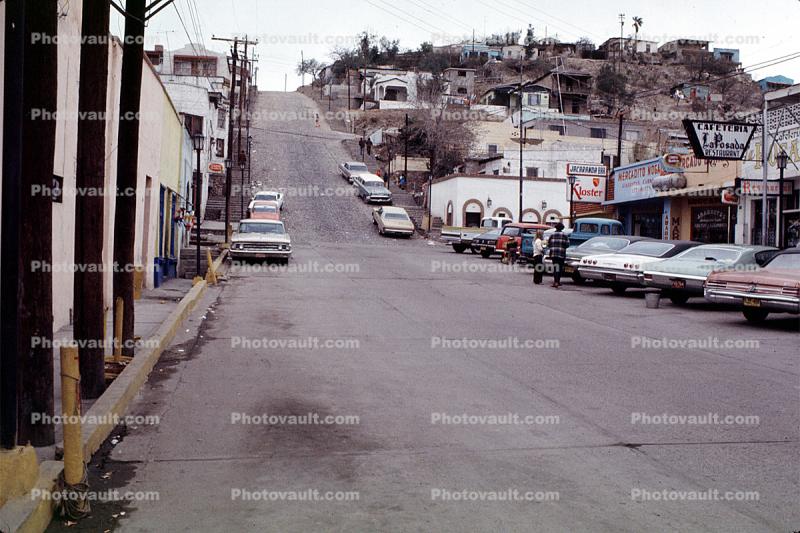 street scene, cars, buildings, hill, automobile, vehicles, Nogales, 1960s