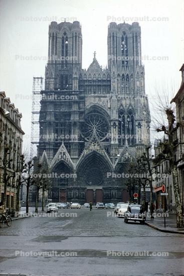 Front facade of a Cathedral, scaffolding, cars, 1950s