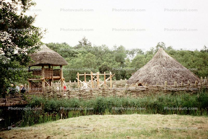 Grass thatched hut, wooden fence, Crannog artificial island, Loch Tay, lake