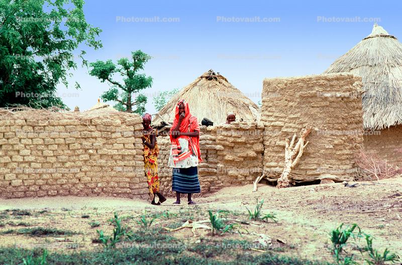 Women in colorful dresses, Grass Thatched Huts, Adobe Wall, Dori, Sod