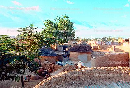 Grass thatched huts, walls, trees, Ouagadougou, Sod