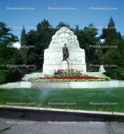 landmark, statue, gardens, water sprinkler, flowers, roadside