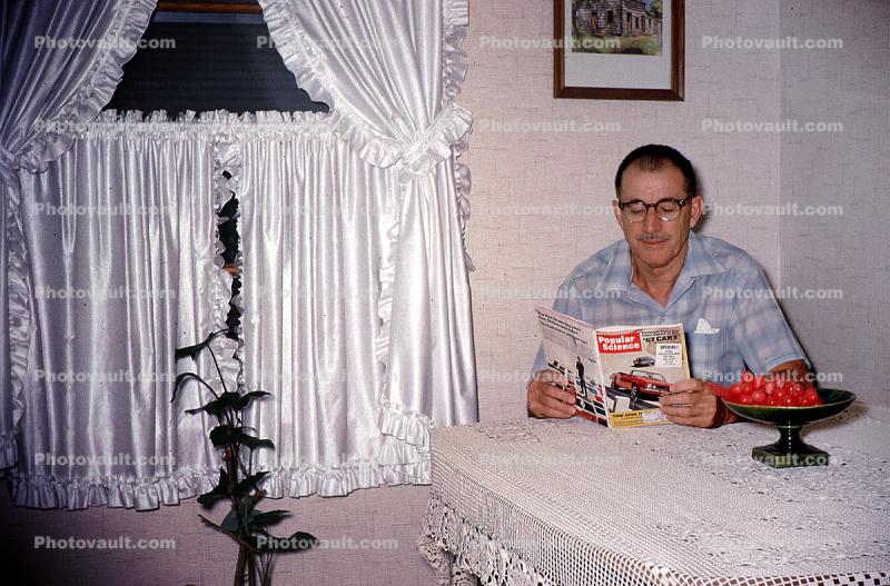 Man reading Popular Mechanics, 1950s