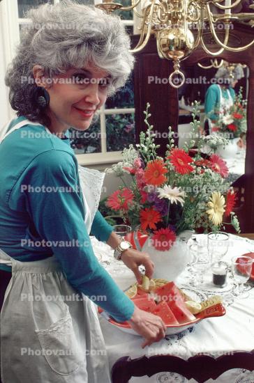Woman Setting a Watermelon Plate on the Table+