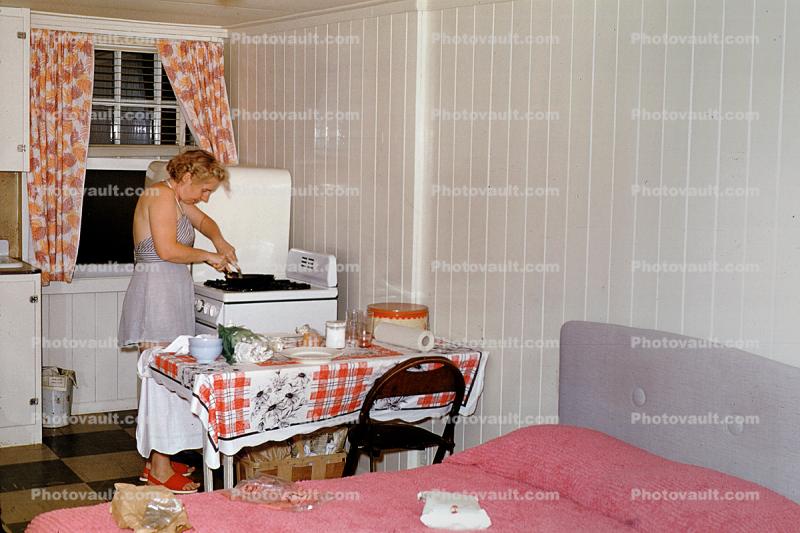 Woman, cooking, frying, steak, meat, table, cottage, stove, bed, 1950s