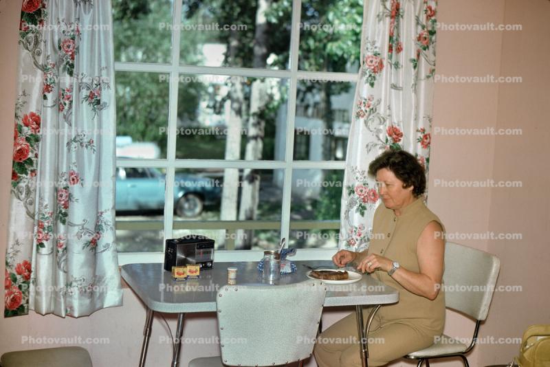 Woman eating lunch, table, transistor radio, 1960s