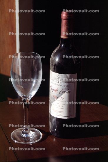 red wine bottle, empty glass