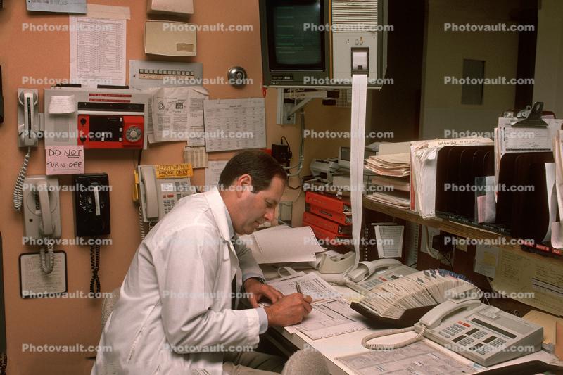 Doctor late at night, telephone, rolodex, file folders