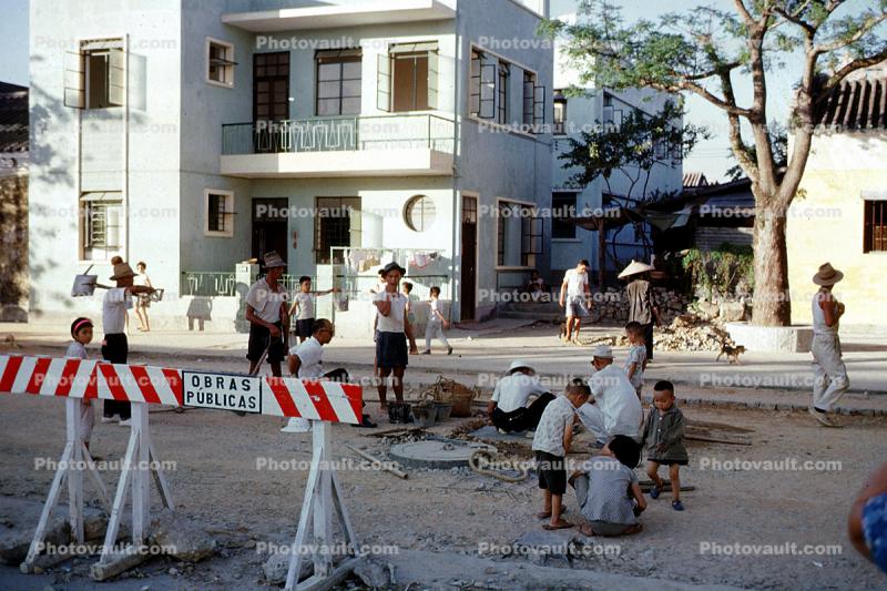 Children playing in the middle of road construction, houses, homes, Macau China, September 1962