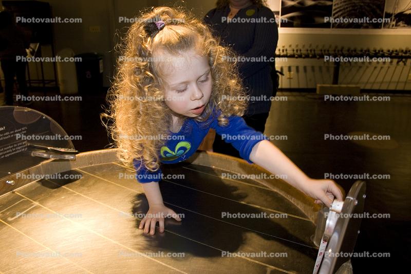 Girl playing with Magnets, hands-on exhibit, touch