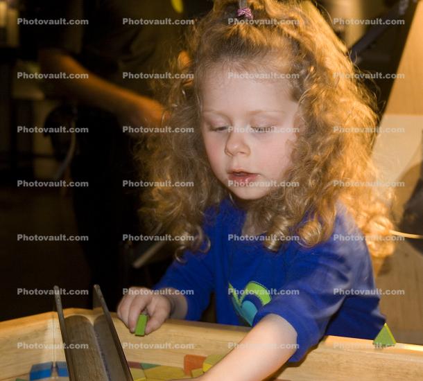 Girl playing with Shapes, hands-on exhibit, touch