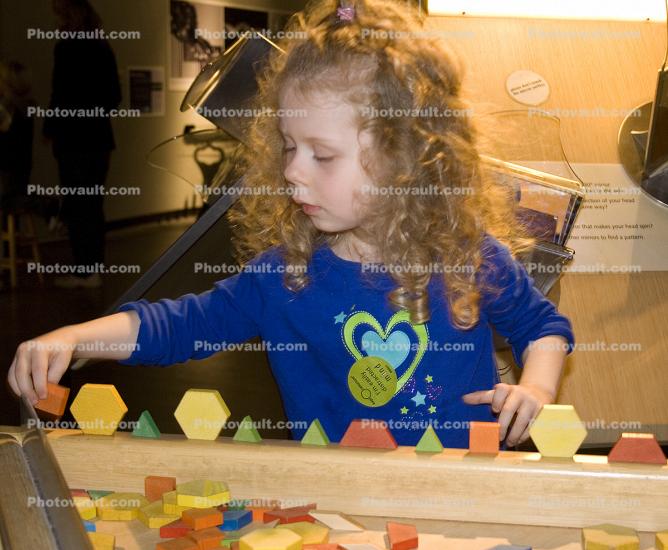 Girl playing with Shapes, hands-on exhibit, touch