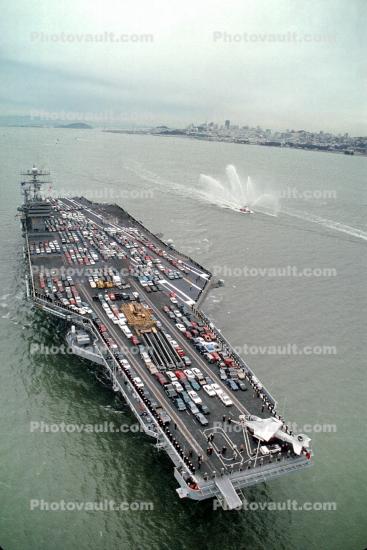 USS Carl Vinson CVN-70, relocating to Washington State, lots of cars, water spraying fireboat
