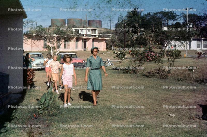 Girl Scouts, walking, cars, lawn, fuel tanks, May 1964, 1960s