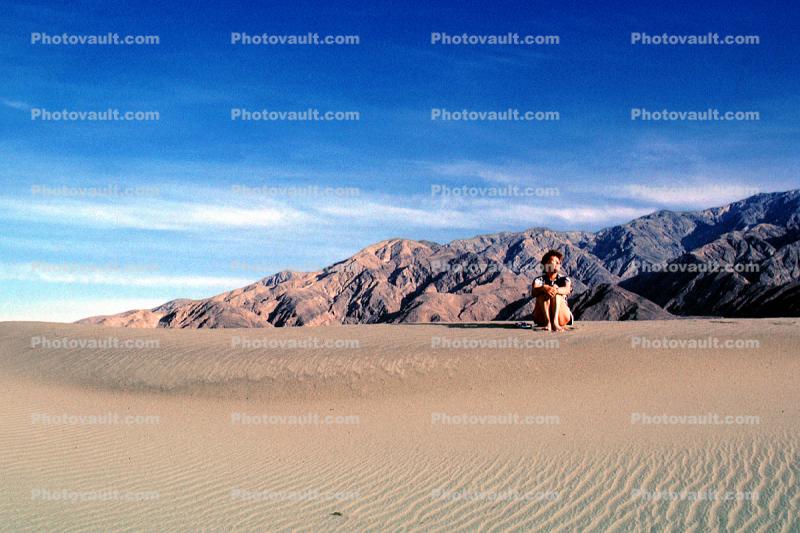 Woman sitting, Sand Dunes, Death Valley National Park, Panamint Mountain Range