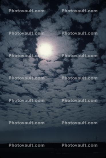 Sun pearing through Altocumulus Clouds, daytime, daylight