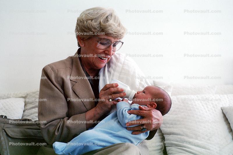 Grandmorther bottle feeding baby boy