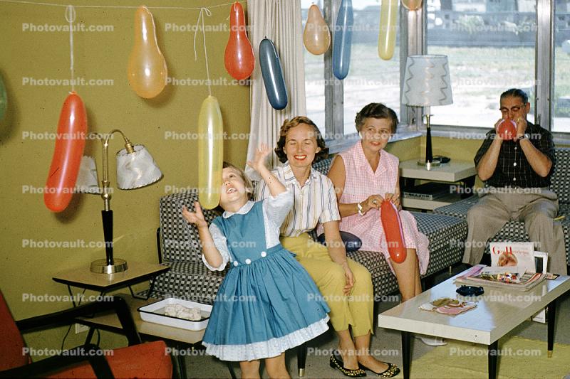 Birthday party girl, sofa, balloons, table, fun, funny, smiles, 1960s