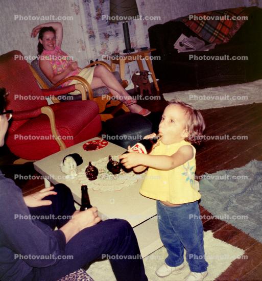 Toddler drinks a beer, girl, funny, chairs, 1960s