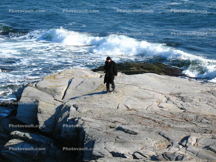 Man Walking on a Rock by the Sea