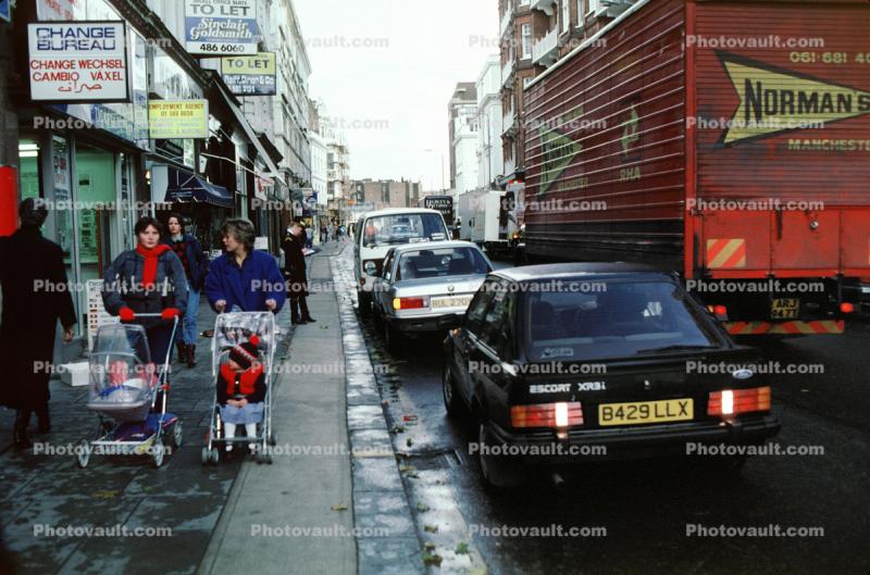 Stroller, women, cars, sidewalk, shops, stores, street