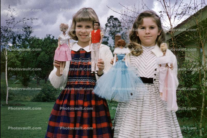 Girls showing off their Barbie Dolls, Ken, smiles, smiling, 1950s