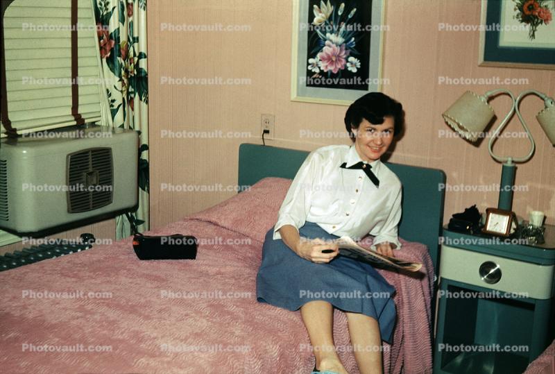 Woman sits on her Bed, smiles, April 1952, 1950s