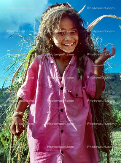 Girl carrying vegetation, smiles, deforestation, desertification