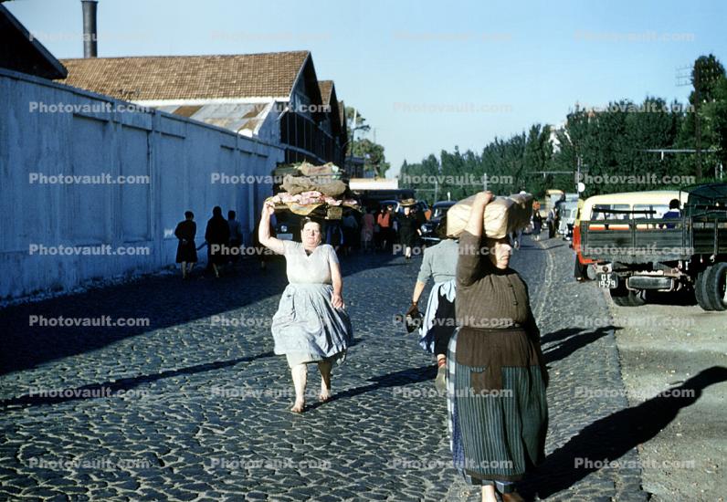 Woman, cobblestone street, 1950s
