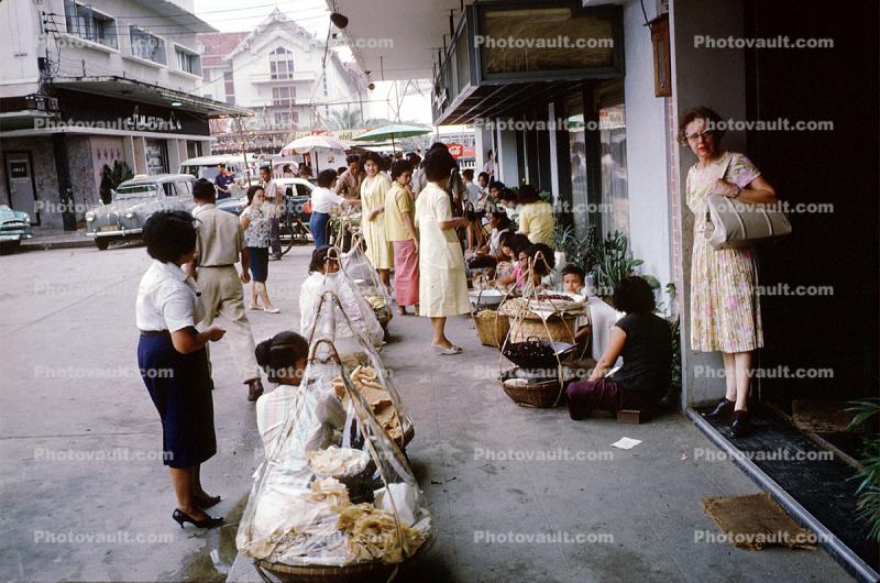 street market, sellers, vendors, shoppers, sidewalk, cars, Bangkok, Thailand, October 1962, 1960s