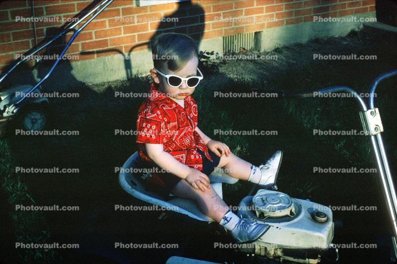 boy on a lawnmower, glasses