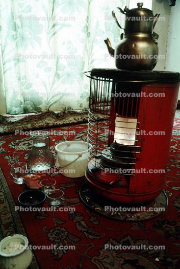teapot on a heater stove, rug, curtains