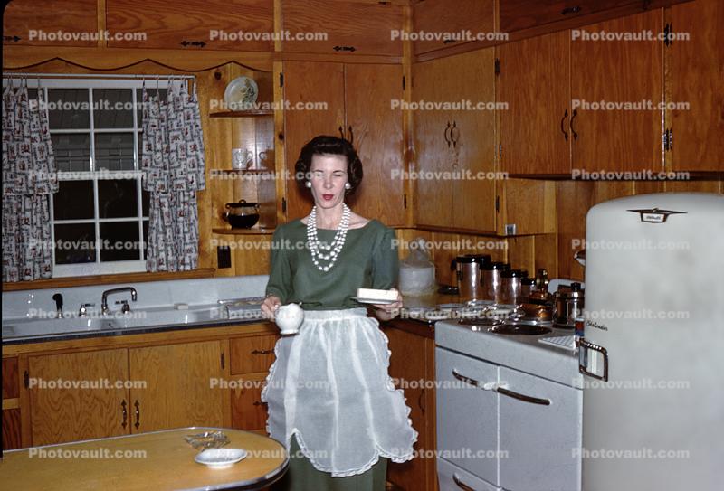 Woman in The Kitchen, Apron, Electric Stove, oven, refrigerator, Sink, Cabinets, counter, 1950s