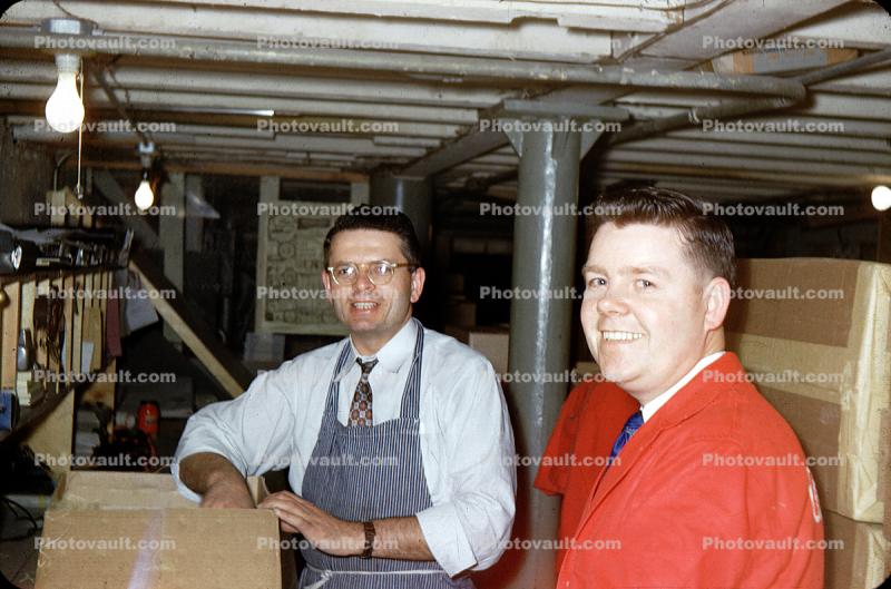 Men in a basement Stockroom, smiles