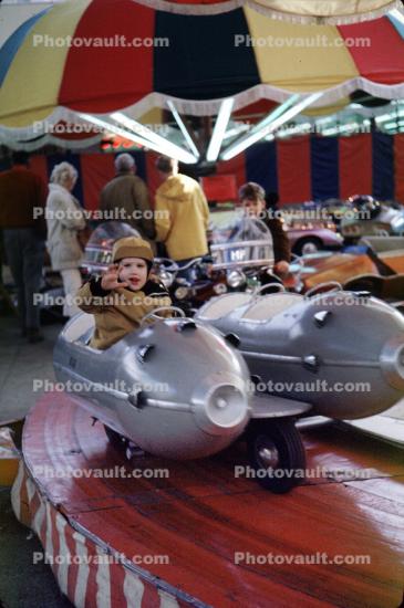 Boy in a rocket jet, smiles, Fair Ride, December 1969, 1960s