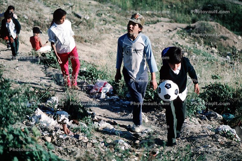Boys, walking, soccer ball, trash, Colonia Flores Magone